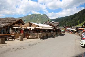 un perro caminando por una calle frente a un edificio en APPARTEMENT PROCHE MORZINE CENTRE ET REMONTEES MECANIQUES - Orée de Morzine 24A, en Montriond 3 fotos más