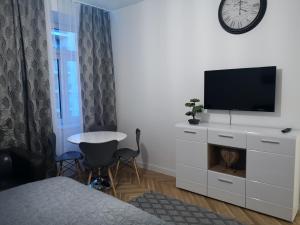 um quarto com uma televisão numa cómoda com uma mesa em Angelika Apartments em Viena