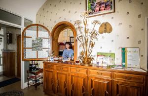 a woman is standing at a counter in a store at Villa Bruderfels, Garni in Rodalben