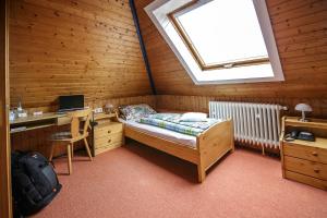 a bedroom with a bed and a desk and a window at Villa Bruderfels, Garni in Rodalben
