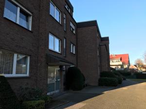 un bâtiment en briques rouges avec un trottoir devant lui dans l'établissement Ferienwohnung An der Gildenstr, à Borken