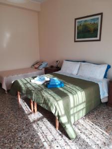 a bedroom with a bed with a green blanket on it at Casa di Angela in Siracusa