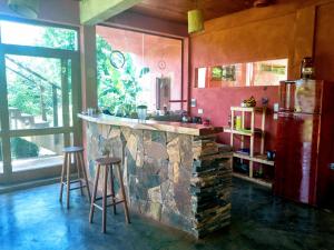 uma cozinha com um grande balcão de pedra e bancos em Nativa Iguazu em Puerto Iguazú