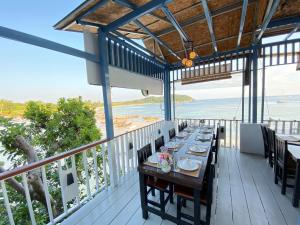 a table on a balcony with a view of the ocean at Chareena Garden in Ko Lipe