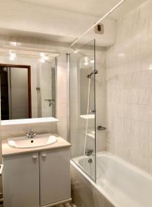 a bathroom with a sink and a shower and a tub at FOLYERE 17 La Tania in La Tania