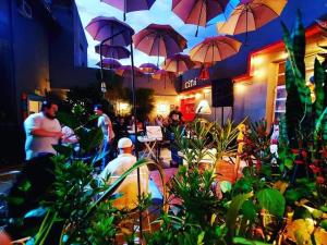 a group of people sitting outside of a restaurant with umbrellas at Casa de Arte CiTá, bed and breakfasts in San Miguel de Tucumán