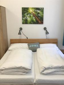 twee bedden in een slaapkamer met twee lampen aan de muur bij Saralo Apartments 1050 in Wenen