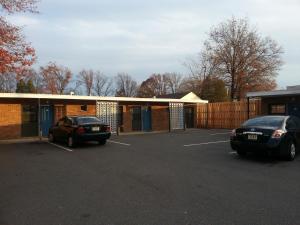 two cars parked in a parking lot in front of a building at Americana Motel in Avenel