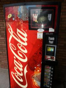 a coca cola vending machine with a cocacola sign on it at Americana Motel in Avenel +12 photos