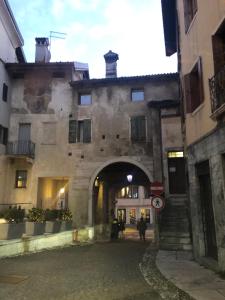 an old stone building with an archway in a street at La Maisonette in Feltre