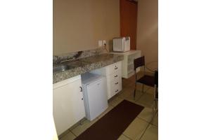 eine kleine Küche mit Spüle und Mikrowelle in der Unterkunft Águas da Serra Rio Quente Flats 205B in Rio Quente