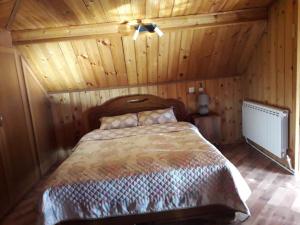 ein Schlafzimmer mit einem Bett in einer Holzhütte in der Unterkunft House in Borjomi in Bordschomi