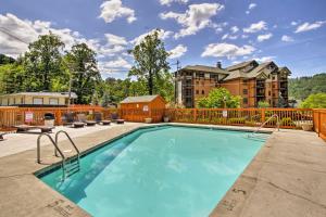 a swimming pool with chairs and a building at Gatlinburg Mountain Townhome with Pool Access! in Gatlinburg