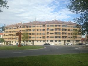 un gran edificio con coches estacionados frente a él en Apartamentos Noluna, en Segovia