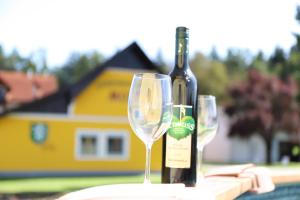 a bottle of wine and two wine glasses on a table at Ferienwohnung Moitz in Heimschuh