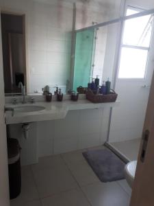 a bathroom with a sink and a mirror at Apartamento Lazer Orquídeas in Santos