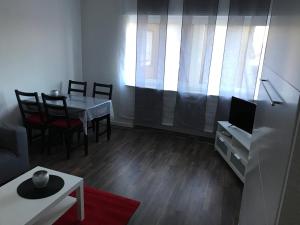 un salon avec une table, des chaises et une télévision dans l'établissement Ferienwohnung An der Gildenstr. 2, à Borken