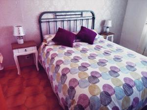 a bedroom with a bed with purple pillows and two tables at Apartamento 3 habitaciones en el centro de Teruel in Teruel