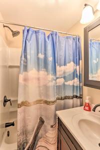 baño con cortina de ducha y lavamanos en Waterfront Syracuse Home with Deck, Fire Pit and Kayaks en Syracuse