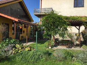 a yard with a fence and a bench in front of a house at Penzion Dukát in Vřesina