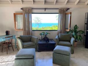 uma sala de estar com duas cadeiras e uma grande janela em Mynt Retreat Bed & Breakfast em Montego Bay