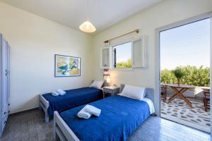 two beds in a room with a balcony at Agnanti Studios in Naousa