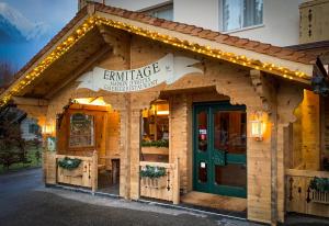 a small building with a green door and lights at Maison d'h&ocirc;tes Ermitage in Chateau-d'Oex