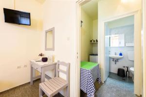 a small bathroom with a desk and a toilet at Agnanti Studios in Naousa +42 photos