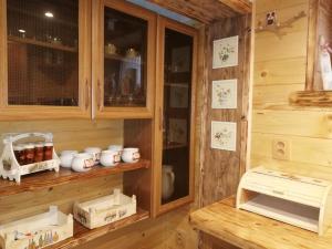 eine Küche mit Holzschränken und einer Theke mit Gläsern in der Unterkunft Chata 67 in Donovaly