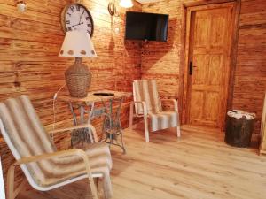 a room with a table and chairs and a clock on the wall at Chata 67 in Donovaly