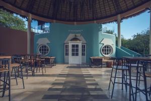 un edificio azul con mesas y sillas en Iberostar Selection Paraíso Lindo, en Puerto Morelos