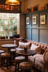 a living room with a couch and tables and windows at The Black Boy in Oxford