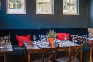 a dining room with wooden tables and a blue couch at The Black Boy in Oxford