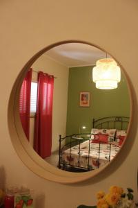 a bedroom with a bed and a round mirror at La Melagrana in Arenella