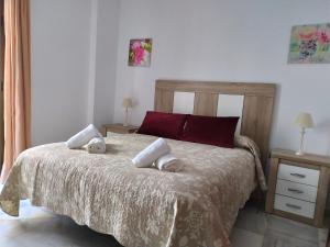 - une chambre avec un lit et des serviettes dans l'établissement Precioso apartamento en el Arenal, à Séville