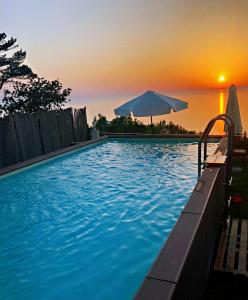 una piscina con ombrellone e tramonto di B&B Il Paradiso di Capri ad Anacapri