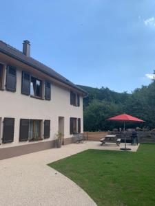 a patio with a picnic table and an umbrella at Les Hirondelles in Wintzenheim