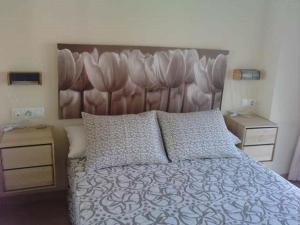 a bedroom with a large bed with a large headboard at Apartamentos Patrisol in Zahara de los Atunes