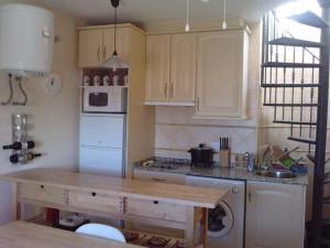 a kitchen with a wooden table in a kitchen at Apartamentos Patrisol in Zahara de los Atunes