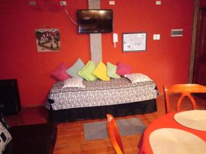 um quarto com uma cama com almofadas coloridas em VALYAK rent apart hotel - Servicios Integrales em Punta Arenas