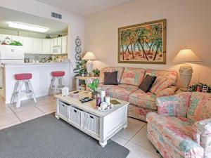a living room with a couch and a table at West Gulf Shores Condo with Ocean Views, Shared Pool in Gulf Shores
