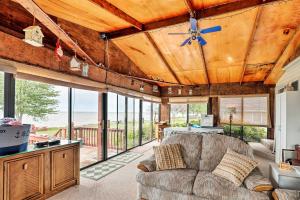 a living room with a couch and some windows at Lyndonville Home with Fire Pit, Screened Patio and AandC in Waterport