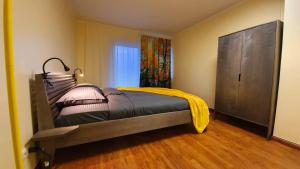 a bedroom with a bed with a yellow blanket on it at Taevaskoja Holiday Center in Taevaskoja