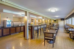 un restaurante con mesas y sillas y un bar en Roosevelt Hotel, en Williston