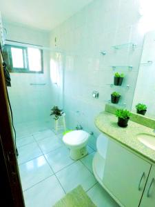 ein weißes Bad mit einem WC und einem Waschbecken in der Unterkunft Lampião Hostel in Florianópolis