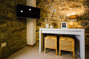Zimmer mit einer Steinmauer, einem Tisch und einem Stuhl in der Unterkunft Vougaldeias Casas da Seara in Sever do Vouga