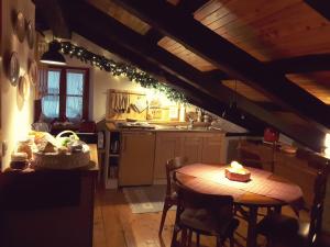 a kitchen with a wooden table and a table and chairs at Casa all’antica fontana in Sùtrio