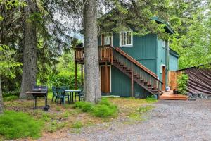 a green house with a deck and a table and chairs at Seward Studio with Deck, Outdoor Dining and Mtn Views! in Seward