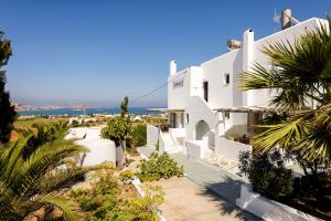 a view of a white building with palm trees at Agnanti Studios in Naousa