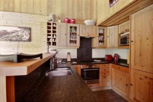 a kitchen with wooden cabinets and a sink at CHALET SAUNA AU PIED DES PISTES - SAINT JEAN D'AULPS STATION - 14 PERSONNES - CHALET PHOENIX in Saint-Jean-d'Aulps